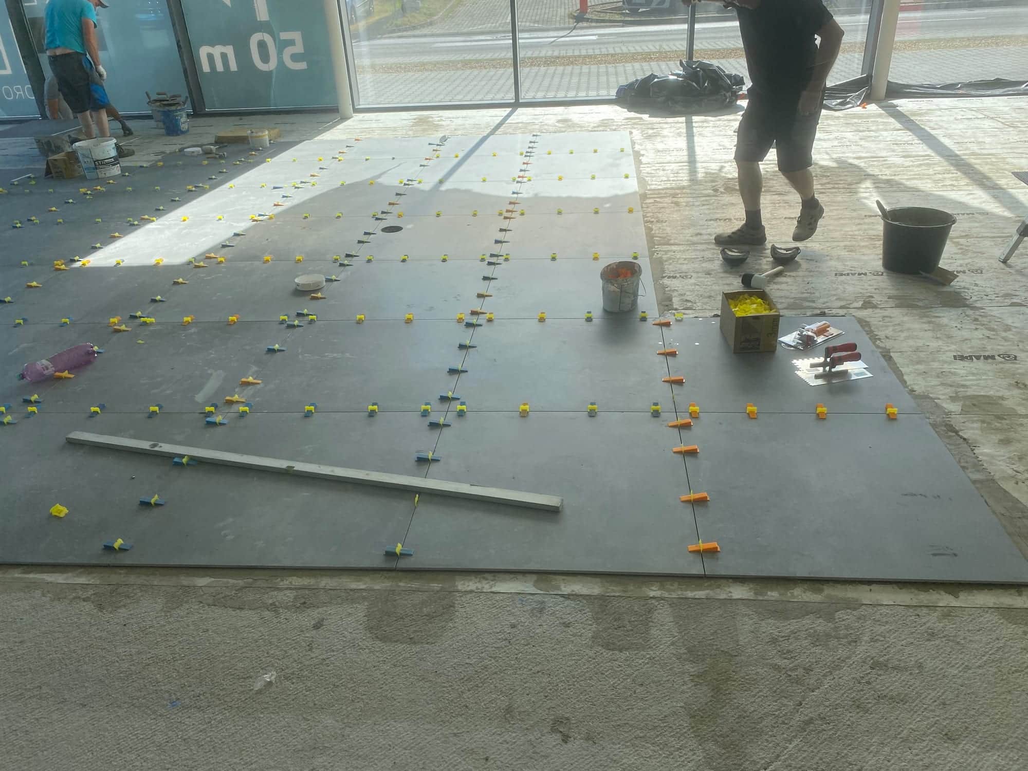 Položené dlaždice 90 x 90 cm s klinmi nivelačného systému po celom obvode každého kusu