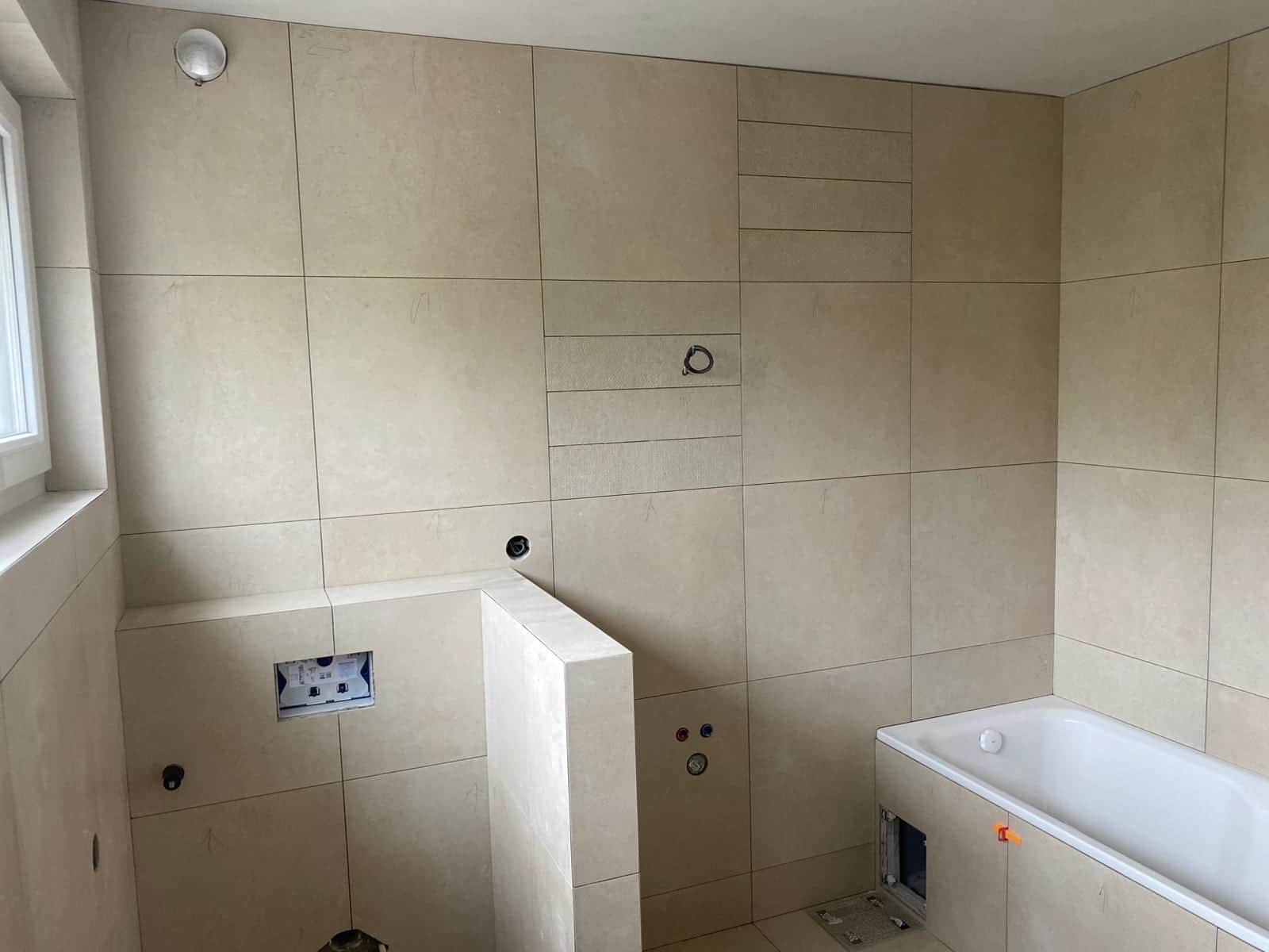 Kúpeľňa s obmurovanou vaňou a predstenou WC v teplom piesočnom veľkoformáte