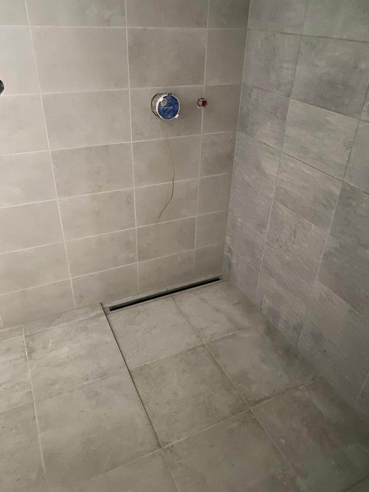 Sprcha bez vaničky so spádom dlažby do lineárneho žľabu pri stene