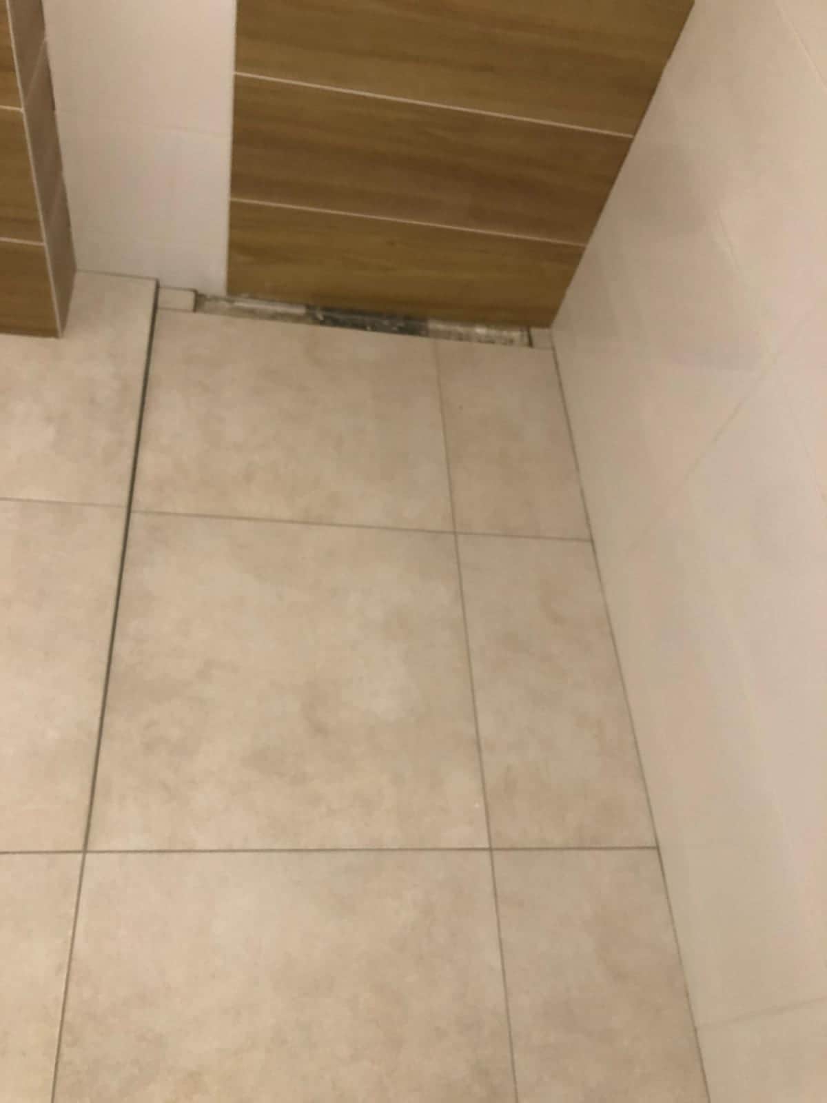 Béžová dlažba so spádom do žľabu osadeného tesne pri stene